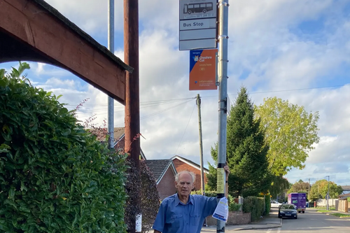 Cllr Ian Marks at a bus stop in Lymm